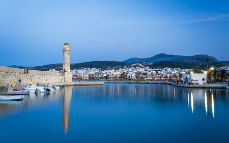 Crete, Greece - April 26 2018: Lighthouse at old Venetian harbour at dusk, Rethymno (Rethymnon),...