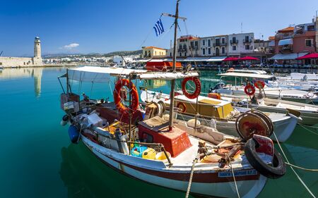 Crete, Greece - April 26 2018: Fishing boat and Lighthouse at old Venetian harbour, Rethymno (Rethymnon), Crete, Greek Islands, Greece, Europeのeditorial素材