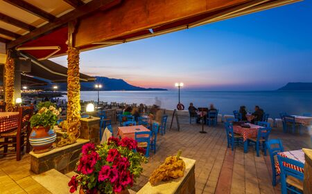 Crete, Greece - April 25 2018: Traditional Cretan Food Restaurant at Paraliaki promenaad at sunset in Kissamos, Crete, Greek Islands, Greece, Europeのeditorial素材