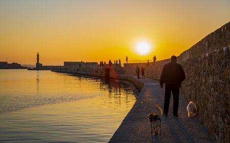 Crete, Greece - April 27 2018: Dusk light over the harbour and the lighthouse silhouetted on the horizon, Chania, Crete, Greece, Europeのeditorial素材