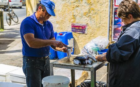 Man cleaning fish, Chania, Crete, Greek Islands Greece Europeのeditorial素材