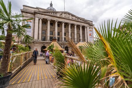 NOTTINGHAM, UK - AUGUST 07, 2019: Council House (City Hall) at Old Market Square with a pool, fountain, sand and beach chairs in the foreground.のeditorial素材