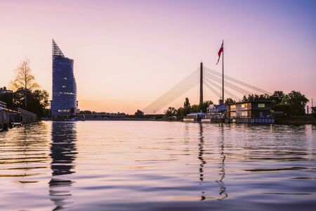 Suspension bridge with huge Latvian flag from AB dam at sunset, Riga, Latvia, Europeの写真素材