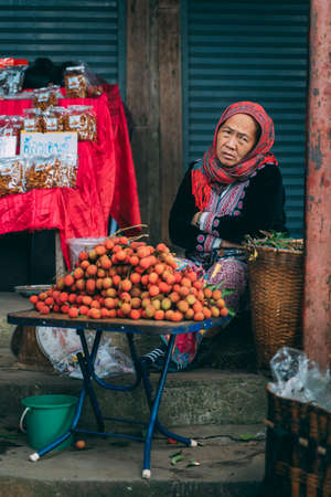 Chiang Mai, Thailand - Decemer 31st, 2019: Old woman selling lychees at fruit stand, Malee doisuthep Market, Chiang Mai, Thailand, Asiaのeditorial素材
