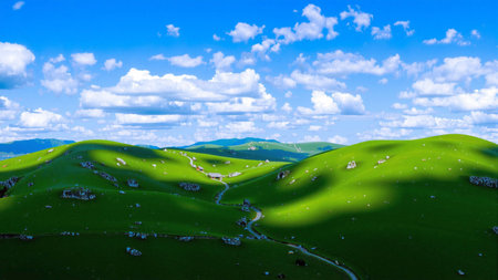 Beautiful landscape with green hills and blue sky with white clouds.の素材