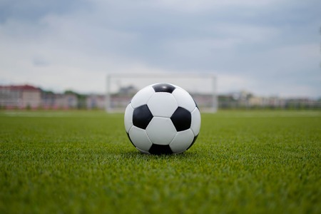 soccer ball with soccer goal on a green lawn