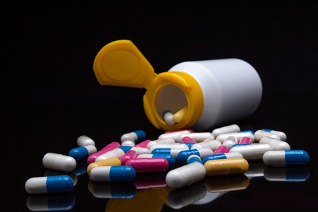 Tablets and pills on a black backgroundの写真素材