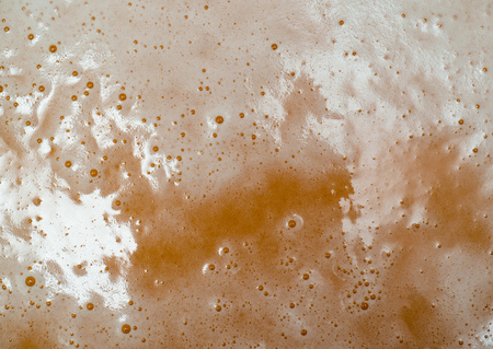 Texture of yellow beer foam close-up