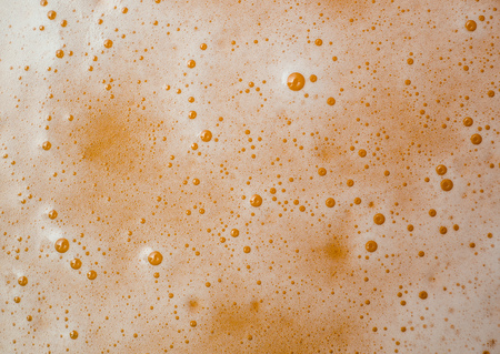 Texture of yellow beer foam close-up