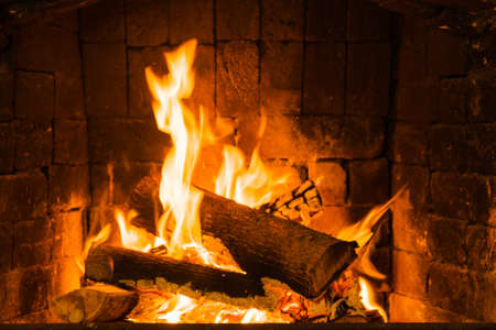 Glowing fire in home stone fireplaceの写真素材