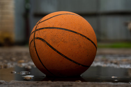 Basketball ball in puddles on the streetの写真素材