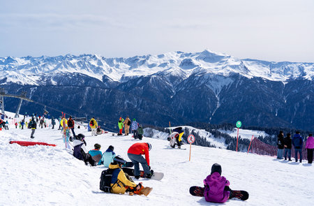 A group of people are snowboarding and sitting on the snowの写真素材