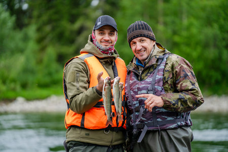 Two fishermen show off their catch of fishの写真素材