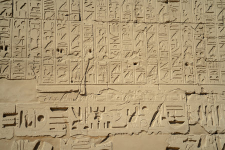 Egyptian ancient wall with hieroglyphs carved in the open air