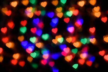 bokeh in the form of colored hearts on a black background