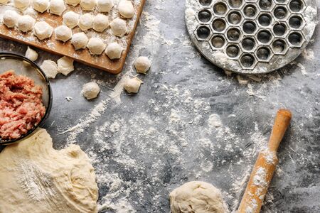 food frame with dough, flour, minced meat, rolling pin and a dumpling mold. Flat lay composition with ingredients for Russian dumplings.の写真素材