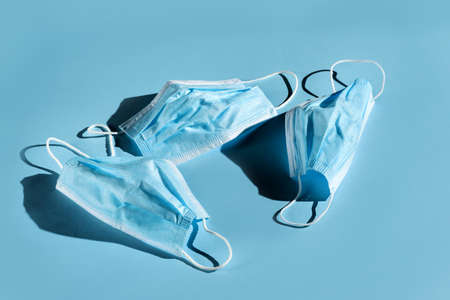 Old medical masks lying on a blue background.の写真素材