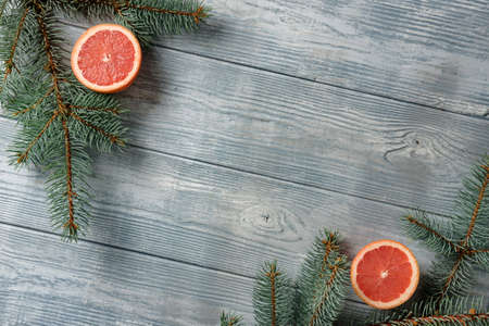 Wooden background with spruce branches and grapefruit halves. The concept of a New Year's card.の写真素材