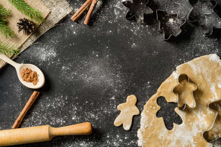 Christmas food frame with gingerbread cookies, bakeware on black background with copy space. Flat lay composition with homemade cakes.の写真素材