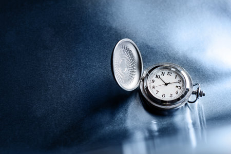 Pocket watch on a rough metal surface with copy space.の写真素材