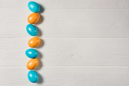 Easter background with painted eggs on a white wooden background with copy space.の写真素材