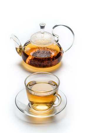 Cup with tea and teapot isolated on white background. The concept of traditional tea drinking.の写真素材