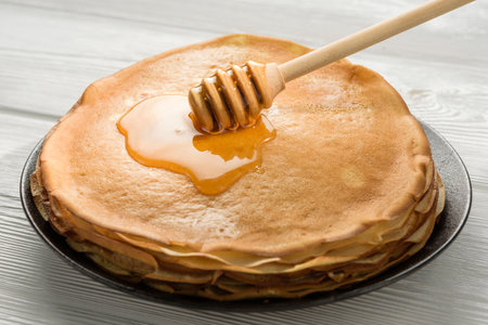 A stack of pancakes with honey close-up. Russian carnival.の写真素材