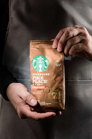 Voronezh, Russia, 02/10/2021. A pack of Starbucks coffee in the hands of a barista close-up.のeditorial素材