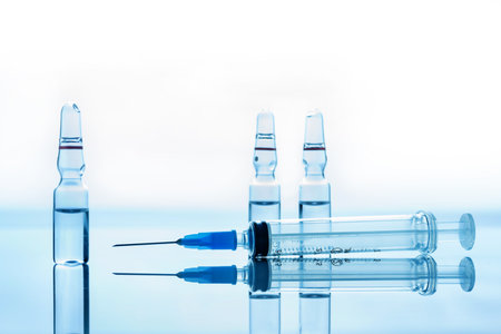 Medical syringe and ampoule with vaccine isolated on white background.の写真素材