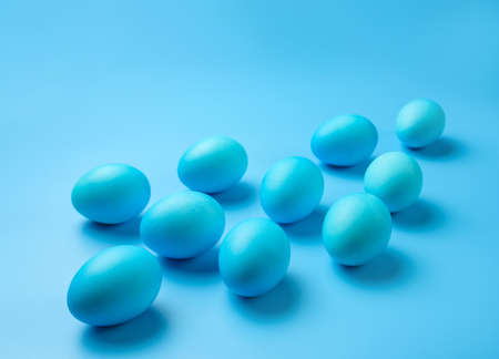 Several Easter eggs of blue color on a blue background with copy space. Easter banner.の写真素材