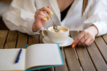 Woman stirring coffee close-up. Business breakfast.の写真素材