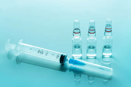 Medical syringe and glass ampoules with medicine close-up.の写真素材