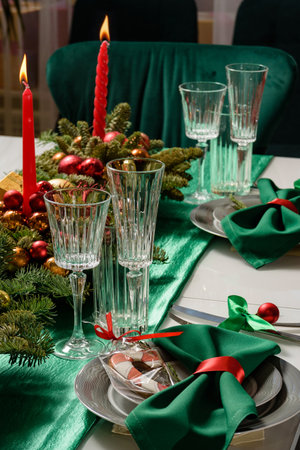 Festive Christmas table decor with candles. Christmas table setting with candles, glasses and fir branches.の写真素材