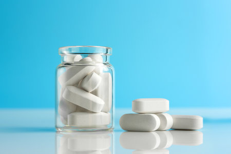 glass bottle with pills close-up on a blue background with copy space.
