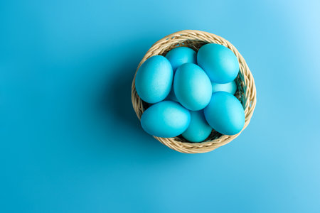 Basket with Easter blue eggs on a blue background with copy space.の写真素材