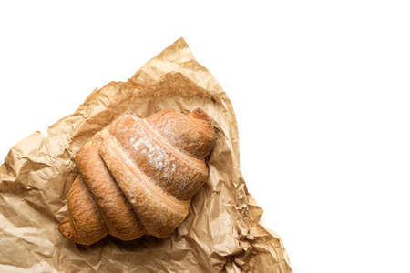 Croissant wrapped in craft paper isolated on white background with copy space.の写真素材