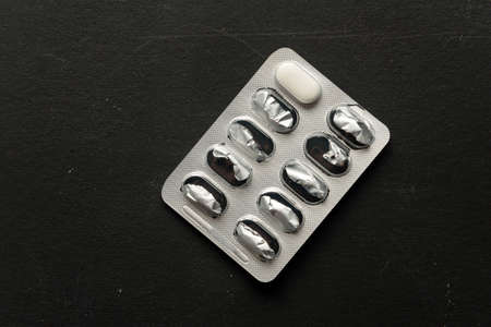 Empty blister with one tablet on a dark background.の写真素材