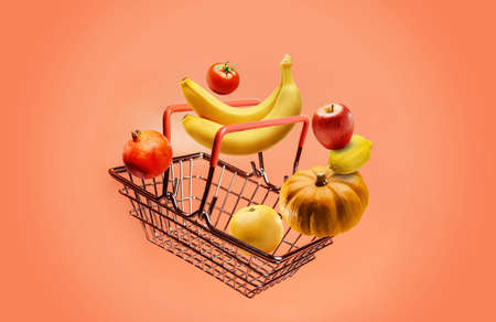 Grocery basket and fruits and vegetables on a pink background with copy space.の写真素材