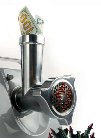 Money is immersed in a meat grinder, from which combat missiles come out. The concept of militarization and weapons.の写真素材