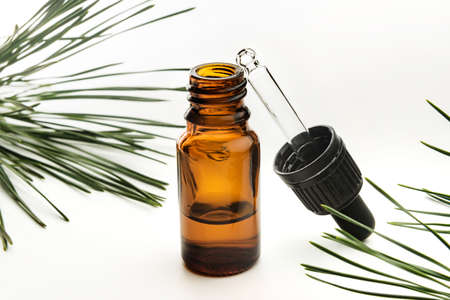Bottle with essential oil and coniferous branches on a white background.の写真素材