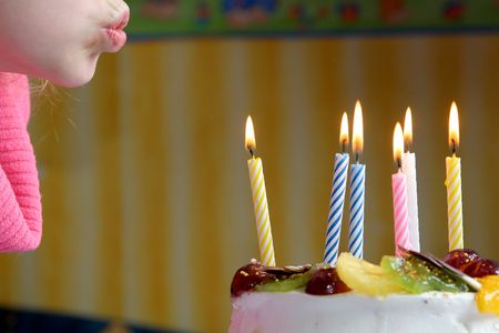 Young girl blowing birthday candles