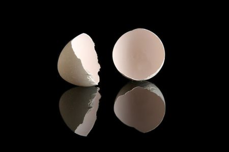 Cracked egg shells on a black backgroundの写真素材