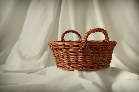 Empty basket on a white fabric  backgroundの写真素材