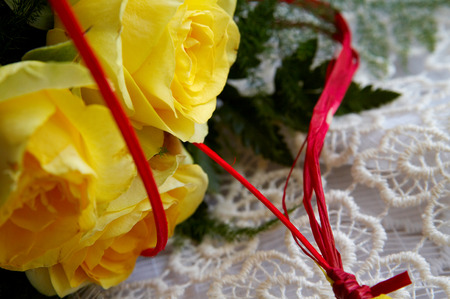 Bunch of yellow roses with red ribbonの写真素材