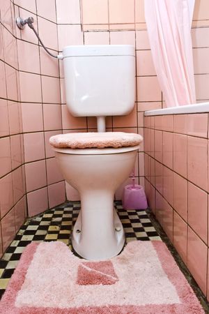 Dirty old  toilet with pink ceramic tilesの写真素材
