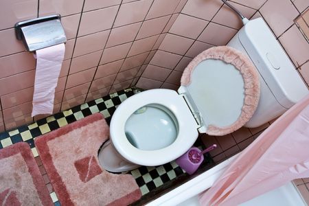 Dirty old  toilet with pink ceramic tiles