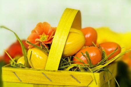 Yellow orange Easter eggs in basket on a light green background