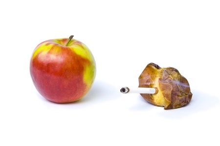 Red apple and rotten apple smoking cigaretteの写真素材