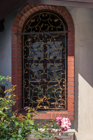 Old window with wrought iron lattice in the courtyard of a houseの写真素材