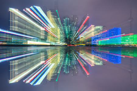 Blurred skyscrapers by night with bokeh lights trail using zoom technique